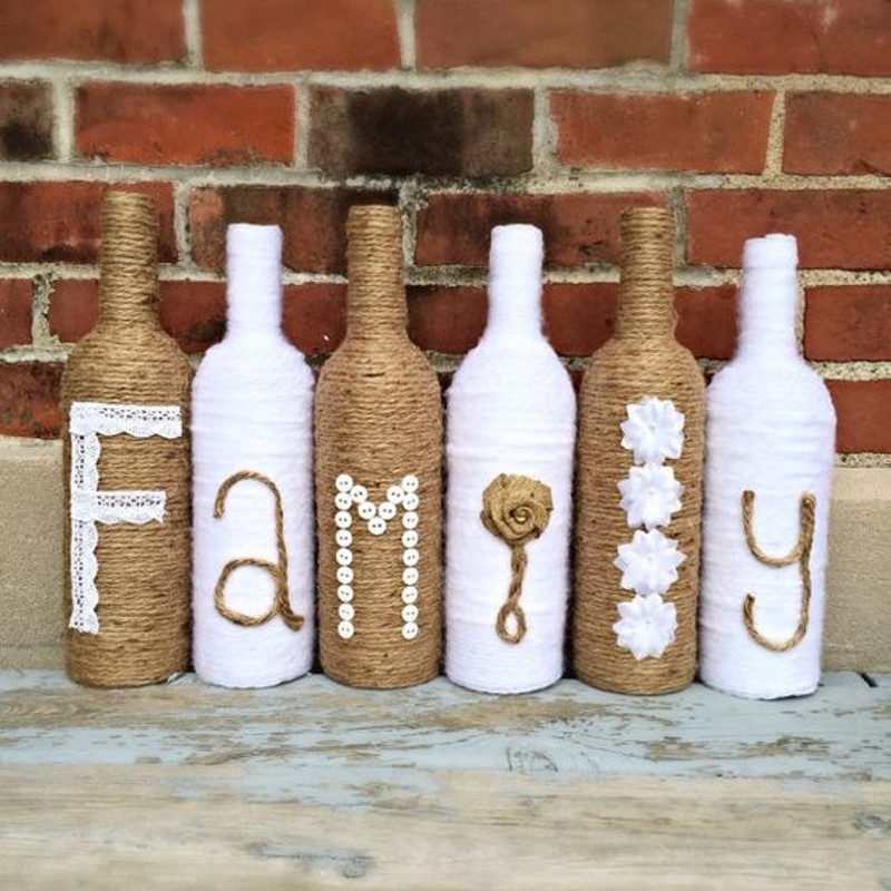 Bottiglie di vino vuote decorate con spago e lana